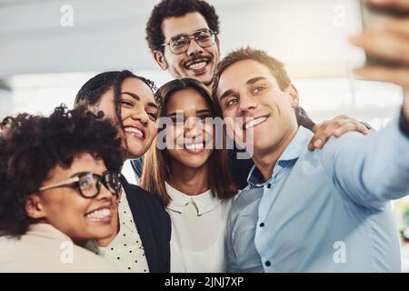 Happy, diverse and carefree colleagues taking a selfie to share on social media on their break. An excited young group of employees having fun at the Stock Photo