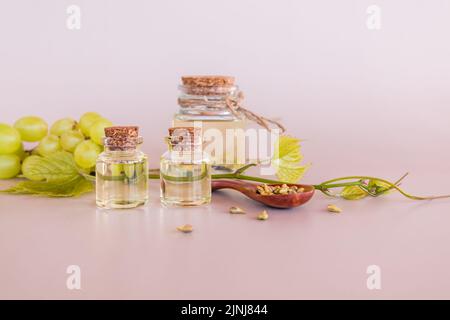 a set of different glass bottles with cork cap with natural organic grape seed oil. elixir of youth. pastel background Stock Photo