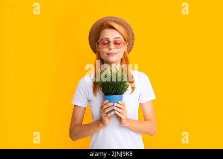 Woman planting flowers in pot. Girl hold flower pot. Concept of growing plants. Summer female gardener. Stock Photo