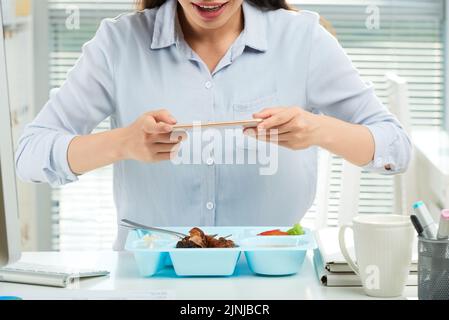 Cropped image of business woman taking photo of lunch before eating it Stock Photo