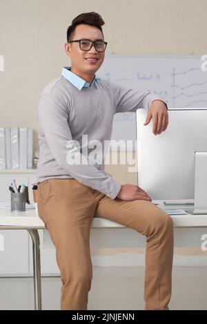 Portrait of young Asian office worker smiling and looking at camera Stock Photo