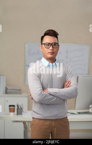Confident young businessman in glasses looking at camera Stock Photo