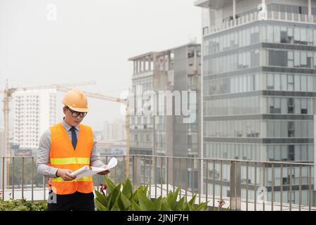 Young Asian engineer working on construction site Stock Photo