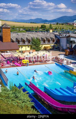 Liptovsky Mikulas, Slovakia - August 4, 2022: People are sliding down on colorful water slides in aquapark Stock Photo