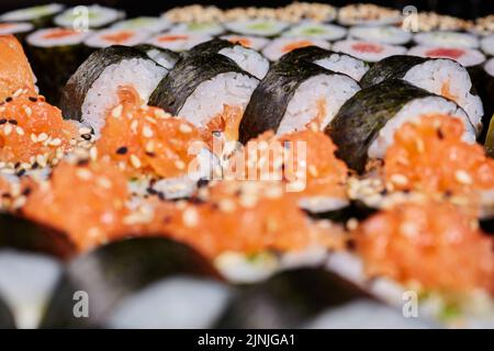 Food background. Close up of Futomaki rolls with different fillings served with sesame seeds. Concept of delicious traditional Japanese cuisine, delic Stock Photo