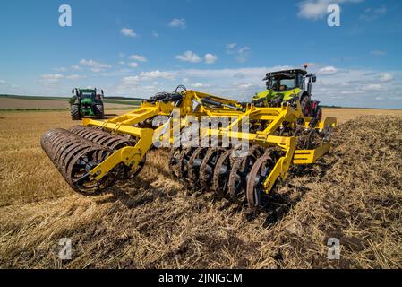 multi-disc cultivator, tillage system in operation with tractor Stock Photo