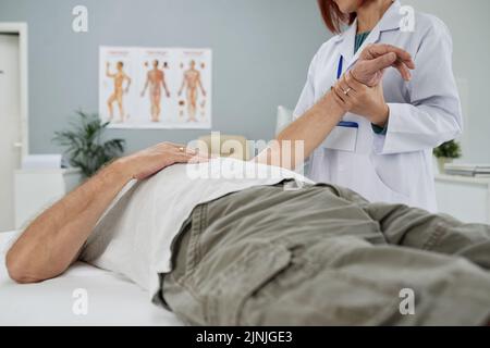Chiropractor examining senior man in her office Stock Photo