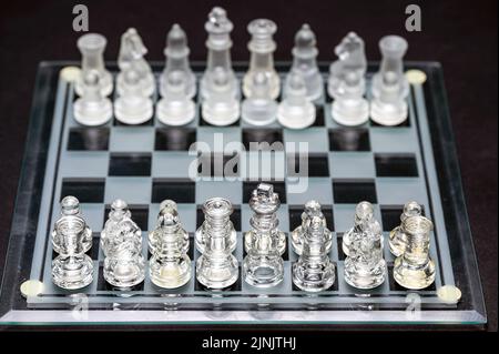 Set of transparent glass chess pieces over black, selective focus, copy space Stock Photo