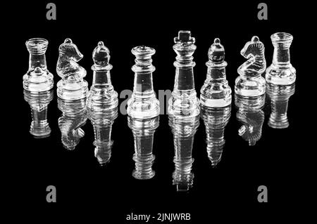 transparent glass chess on black background, selective focus on king and queen pieces, close-up Stock Photo