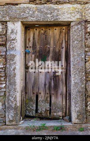 Old wooden door in medieval stone house. Stock Photo