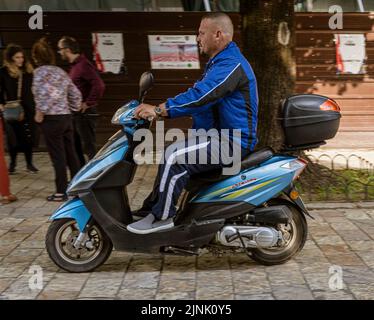 Albania, May 12, 2022 - man riding moped on street. Stock Photo