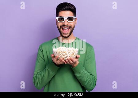 Photo of young impressed astonished open mouth guy hold popcorn in hands wear 3d glasses staring isolated on violet color background Stock Photo
