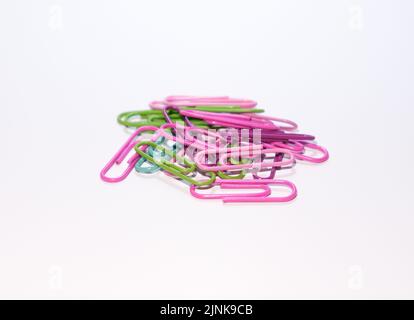 A group of colorful paper clips on isolated white background. Selective focus of paper clips. Stock Photo