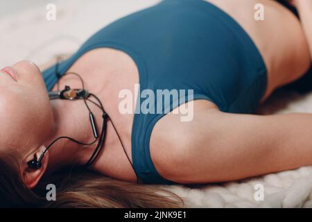 Adult mature woman doing yoga nidra and lie at home with online tutorials on laptop Stock Photo