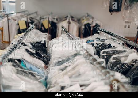 Rack of clean clothes hanging on hangers at dry-cleaning Stock Photo - Alamy