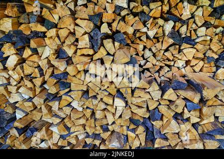 Pile of cut and stacked firewood in various colors. Background. Stock Photo
