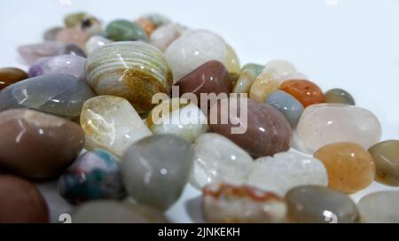 A heap of tumble finished mixture of semi-precious stones on a white background. Stock Photo