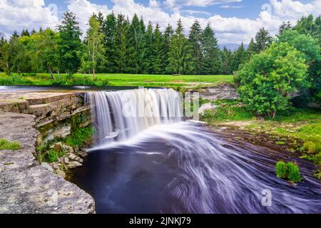 Large river waterfall falling down the cliff in a green forest landscape of northern Europe. Stock Photo