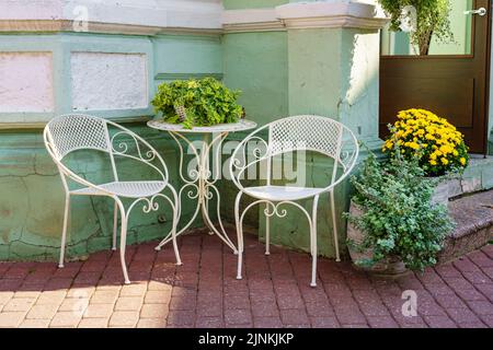 White metal chairs and tables outdoors to rest and relax. Stock Photo