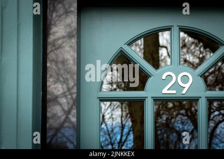 House number 29 with dark trees reflecting Stock Photo - Alamy