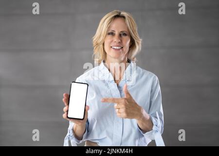 Senior Grandmother Showing Mobile Phone. Holding Smartphone Stock Photo