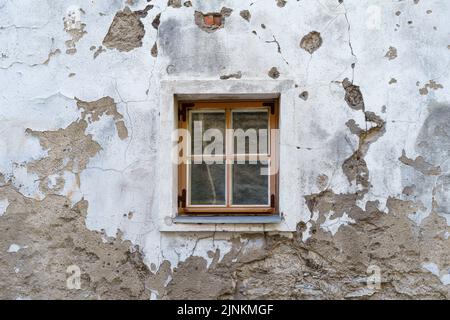 Small window in very old medieval and dilapidated building. Stock Photo
