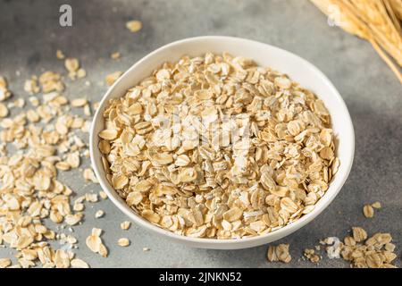 Dry Organic Rolled Oats Oatmeal in a Bowl Stock Photo