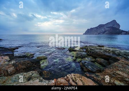 Big rocks on the seashore and waves crashing against them. Stock Photo