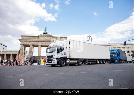 Berlin, Germany. 12th Aug, 2022. Several trucks drive along the Straße des 17. Junis in front of the Brandenburg Gate during a demonstration against rising LNG prices. Credit: Fabian Sommer/dpa/Alamy Live News Stock Photo