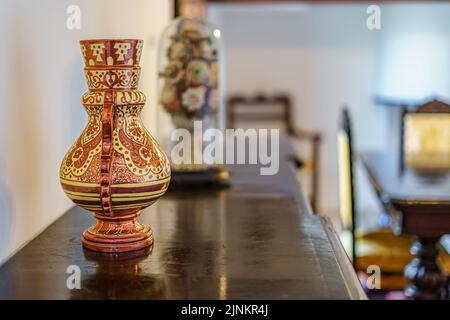 Antique ceramic vase in room with vintage decor. Stock Photo