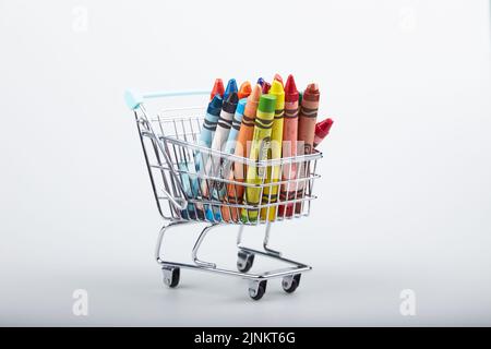 Crayons in a shopping cart isolated on white background Stock Photo
