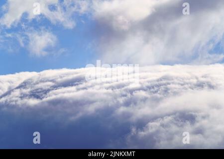 Background of high clouds covering the mountain and blue sky above the clouds. Stock Photo