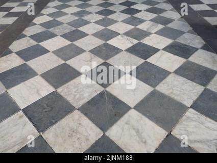 View of black and white geometric tiled chequered marble floor Stock Photo