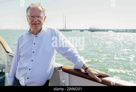 Wilhelmshaven, Germany. 12th Aug, 2022. Stephan Weil (SPD), Minister President in Lower Saxony, stands on a ship in front of the construction site for the planned LNG terminal. Weil visited the future jetty together with Lower Saxony's Environment Minister Lies. Credit: Hauke-Christian Dittrich/dpa/Alamy Live News Stock Photo