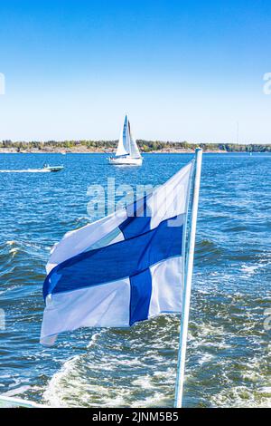 The Finnish national flag (Siniristilippu) flying from the stern of the Suomenlinna ferry off Helsinki, Finland Stock Photo