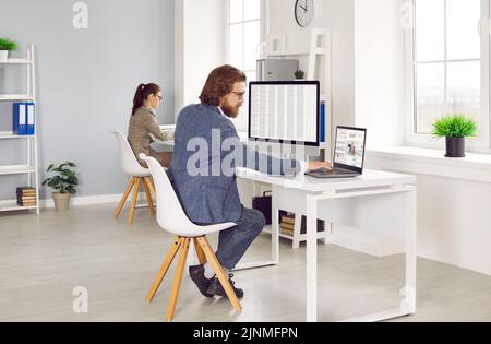 Two professional financial accountants working on computers in modern office interior Stock Photo