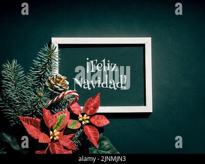 Feliz Navidad is Merry Christmas in Spanish language. Christmas festive background in red, black and dark green. Stock Photo