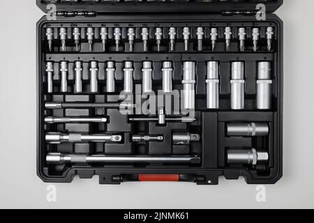 Wrenches of different sizes with different hex heads in a black box on a white table. View from above Stock Photo