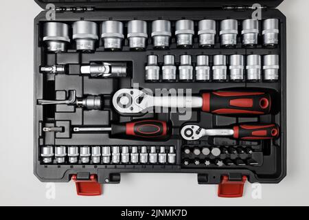 Wrenches of different sizes with different hex heads in a black box on a white table. View from above Stock Photo