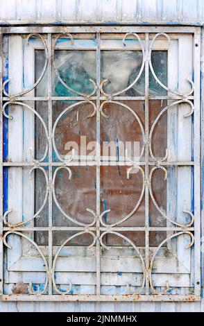 Old window with grating and paint spots Stock Photo