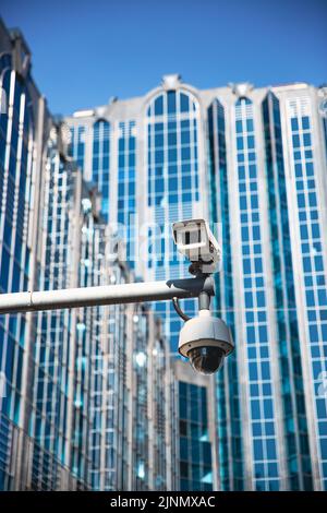 A CCTV surveillance camera on a modern city street being used for intelligence gathering and the focus of human rights liberties and crime prevention Stock Photo