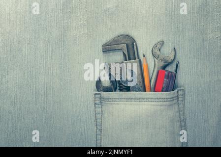 Worn and weathered blue jeans with work tools in the pocket. Home improvement or diy project, Labor Day, or Father's Day concept. Stock Photo