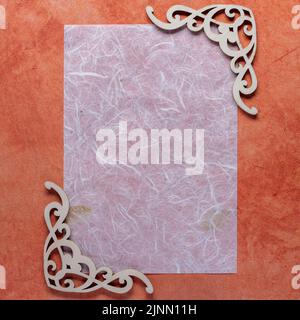fiber paper with wood decor corners on a textured orange background in square format Stock Photo
