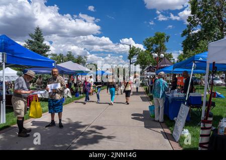 Colorado Springs, CO - July 6, 2022: People shopping and a man is collecting signatures at the Colorado Farm and Art Market located on the grounds of Stock Photo