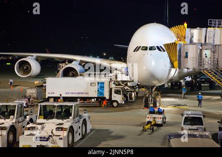 Jet airliner serviced at gate night Narita Airport near Tokyo Japan Stock Photo