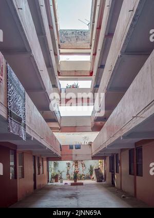 apartment building, central courtyard, pink walls, clothes hanging on the railings Stock Photo