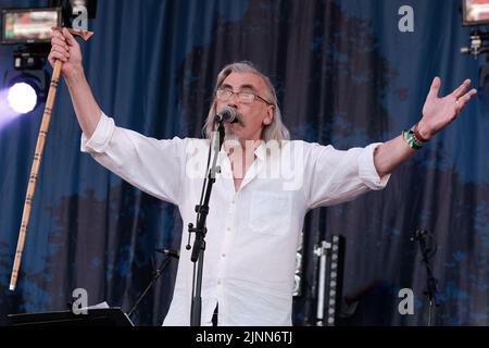 Cropredy, UK. 12th Aug, 2022. John Tams, English actor, singer, songwriter, composer and musician and son of a publican, former member of Derbyshire folk group Muckram Wakes, with British folk rock group Home Service performing live on stage at Fairport Convention's Cropredy Festival. Home Service is a British folk rock group, formed in late 1980 from a nucleus of musicians who had been playing in Ashley Hutchings' Albion Band. Their career is generally agreed to have peaked with the album Alright Jack and has had an influence on later work John Tams and several other members of the band, have Stock Photo