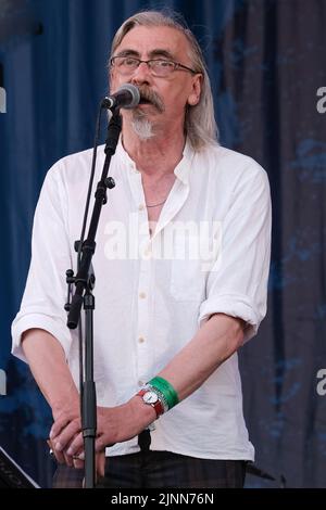John Tams, English actor, singer, songwriter, composer and musician and son of a publican, former member of Derbyshire folk group Muckram Wakes, with British folk rock group Home Service performing live on stage at Fairport Convention's Cropredy Festival. Home Service is a British folk rock group, formed in late 1980 from a nucleus of musicians who had been playing in Ashley Hutchings' Albion Band. Their career is generally agreed to have peaked with the album Alright Jack and has had an influence on later work John Tams and several other members of the band, have had solo careers and worked i Stock Photo