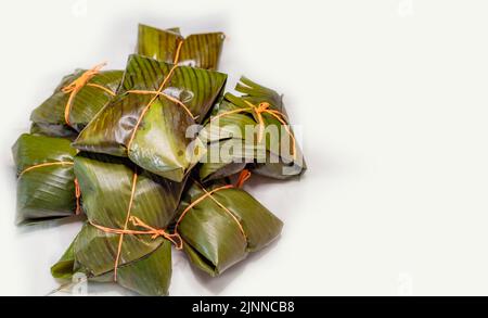 View of homemade Nicaraguan nacatamales with banana leaf on white background, Traditional food Mexican Nacatamales isolated. Traditional Nacatamales Stock Photo