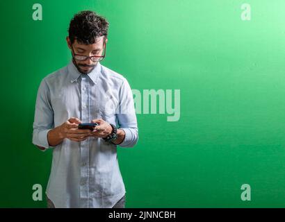 View of handsome man using cell phone isolated, Isolated person in glasses using smart phone, Guy in glasses smiling at cell phone isolated Stock Photo